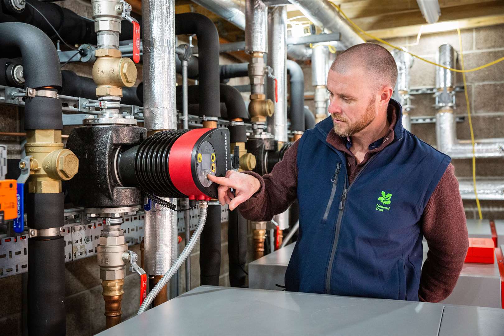 Owen Griffith, project manager at the National Trust, inspects the heat pump at Kingston Lacy (James Dobson/National Trust/PA)