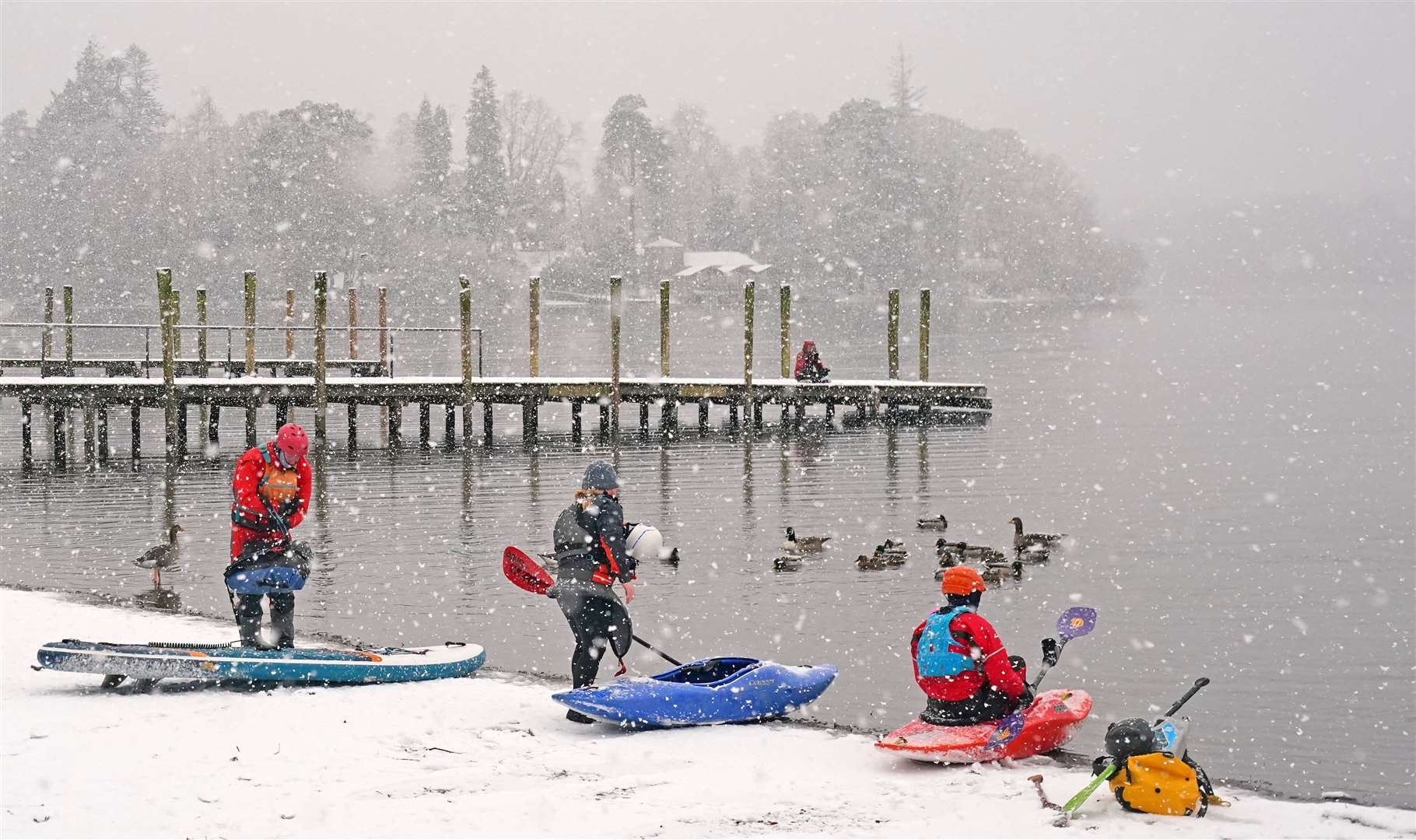 Canoeists, kayakers and paddleboarders in snowy conditions on Derwent Water, Keswick (Owen Humphreys/PA)